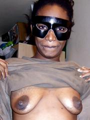 Ugly black female wearing a mask bares his saggy boobs